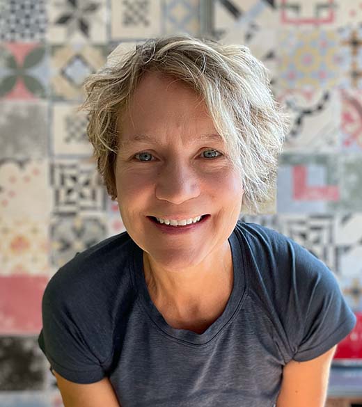 Stephanie Ashenfelder with short blond hair wearing a grey shirt.